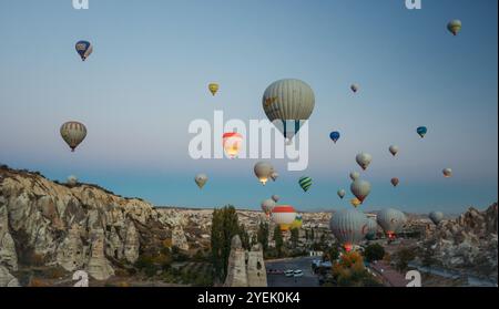 Le mongolfiere si innalzano con grazia nel cielo di prima mattina sopra la Cappadocia, mostrando le sue formazioni rocciose uniche e il paesaggio mozzafiato. Foto Stock