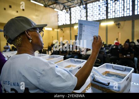 Gaborone, Botswana. 31 ottobre 2024. Un membro dello staff conta le schede elettorali in un seggio elettorale a Gaborone, Botswana, 31 ottobre 2024. Mercoledì i cittadini del Botswana si sono recati ai seggi elettorali per votare i nuovi parlamentari e le autorità locali. Secondo la legge elettorale del paese dell'Africa meridionale, il voto determinerà 61 membri dell'Assemblea nazionale e 609 consiglieri locali, con il partito che detiene almeno 31 seggi in parlamento da dichiarare vincitore. Crediti: Han Xu/Xinhua/Alamy Live News Foto Stock