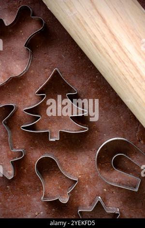 Pasta di pan di zenzero arrotolata, mattarello in legno e varie forme di frese per biscotti natalizi in metallo con motivi tradizionali cechi. Il processo di m Foto Stock