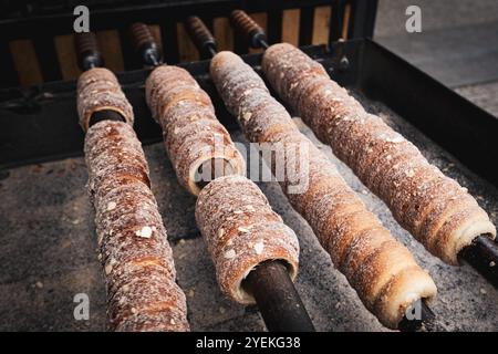 Trdlo i tipici dolci cechi vengono arrostiti al fuoco in un mercato di strada a Praga Foto Stock