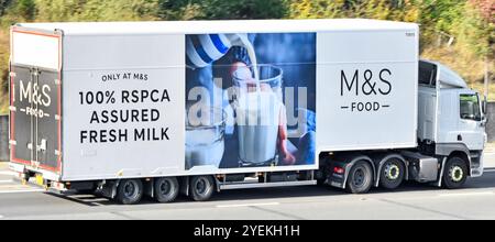 La pubblicità per la vista laterale del rimorchio articolato del camion hgv bianco M&S FOOD collegata al 100% RSPCA assicurava il versamento di latte fresco in vetro sull'autostrada M25 in Inghilterra e Regno Unito Foto Stock