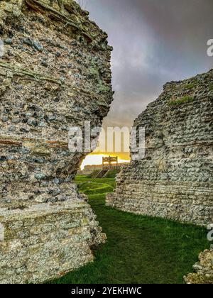 Il forte romano di Richborough al tramonto guardando verso la replica della porta romana in legno Foto Stock