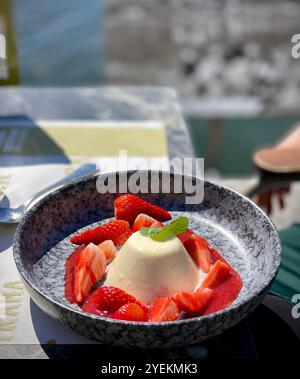 Mangiare il dessert panna cotta vicino al Lago maggiore ad Ascona, Svizzera Foto Stock