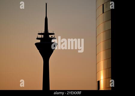 Duesseldorf, Germania. 31 ottobre 2024. Il sole tramonta dietro la Torre del Reno. Alla fine della settimana, gli abitanti della Renania settentrionale-Vestfalia dovranno prepararsi per le nuvole e per le inondazioni occasionali - il sole dovrebbe aumentare solo la domenica. Crediti: Federico Gambarini/dpa/Alamy Live News Foto Stock