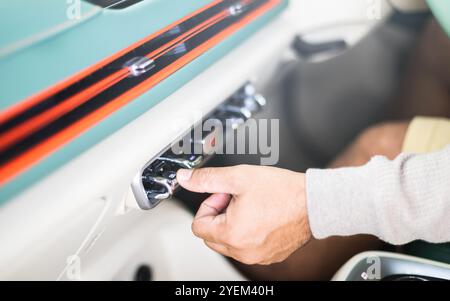 Il proprietario di un'auto regola manualmente la direzione della presa d'aria, garantendo un flusso d'aria ottimale all'interno del veicolo. Manutenzione corretta del veicolo e aria condizionata corretta Foto Stock