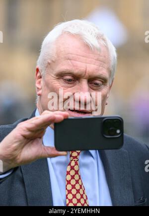 Graham Stuart MP (con: Beverley and Holderness) su College Green, Westminster, filmando la sua risposta al bilancio del governo laburista sul suo mobi Foto Stock