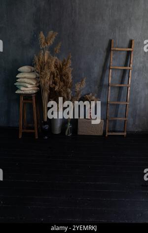 Fiori secchi piante in vasi e sedia in legno nell'interno della sala grigia Foto Stock