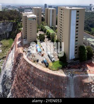 Lavori di rinforzo della scogliera su un tumulo con edifici alti Foto Stock