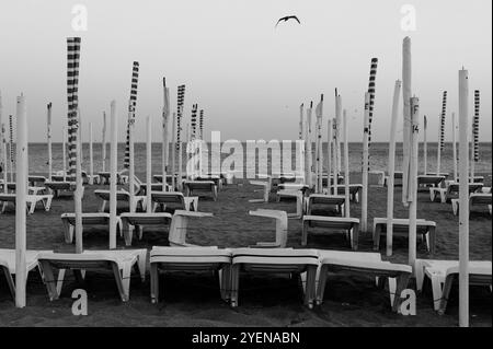 Vista monocromatica dei lettini da spiaggia vuoti che si affacciano sul mare di Albufeira, catturando un'atmosfera tranquilla e bassa stagione Foto Stock