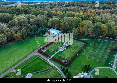 Un giardino splendidamente paesaggistico con un padiglione centrale e aiuole curate, incorniciate da colorati alberi autunnali. La lussureggiante vegetazione aggiunge alla tranquillità generale. Foto Stock