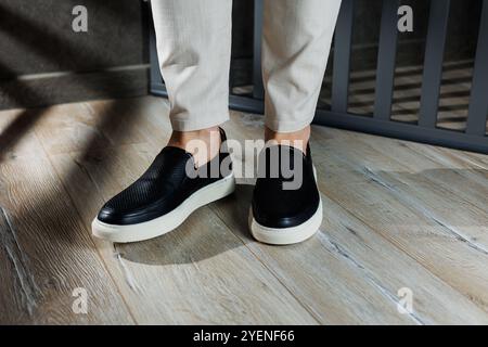 Gambe maschili in scarpe di pelle. Comode scarpe nere da uomo senza lacci. Mocassini casual da uomo Foto Stock