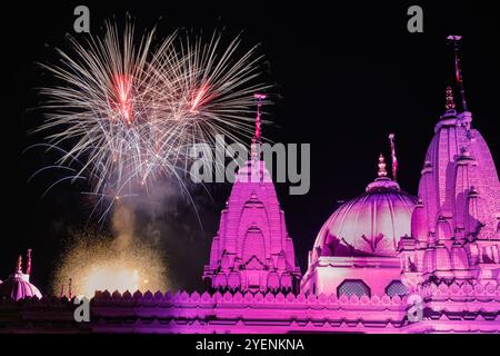 Londra, Regno Unito. 31 ottobre 2024. I festeggiamenti si chiudono con vivaci fuochi d'artificio, visti qui con il tempio illuminato in primo piano. Diwali, il Festival indù delle luci, viene celebrato presso il BAPS Shri Swaminarayan Mandir, popolarmente conosciuto come il Tempio Neasden, con un festival gratuito di cerimonie tradizionali, culto e attività familiari. Il bellissimo tempio tradizionale in pietra indù è uno dei più grandi costruiti al di fuori dell'India. Crediti: Imageplotter/Alamy Live News Foto Stock