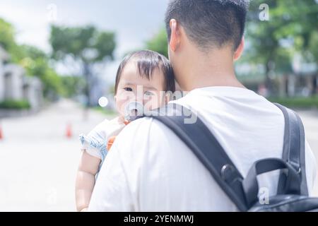 Una ragazza taiwanese di 1 anno che esce con suo padre, un uomo di 20 anni, in una calda giornata di sole per le strade di Taichung, Taiwan, a settembre. Foto Stock