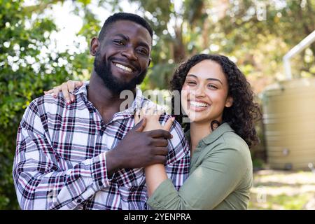 Abbracciare all'aperto, sorridere coppie multirazziali che si godono una giornata di sole insieme nel parco. felicità, natura, estate, tempo libero, relazione Foto Stock