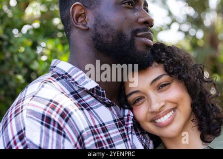 Abbracciate all'aperto, coppie multirazziali che condividono momenti di pace con sorrisi. amore, affetto, felicità, connessione, relax, stile di vita Foto Stock