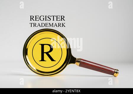 Concetto di protezione del copyright. Registrazione o registrazione del marchio. Lente d'ingrandimento con marchio e logo Register su schermo virtuale. Foto Stock