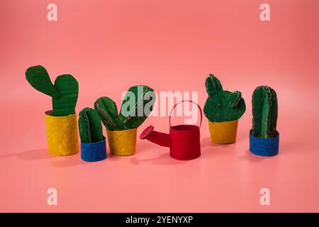 bizzarro abbeveratoio in cartone, progettato come giocattolo per bambini. Un mix fantasioso di arte e gioco, un vivace gruppo di piante di cactus ag Foto Stock