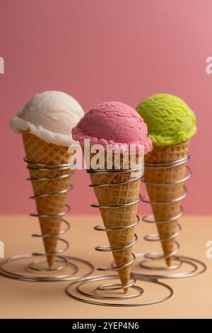 Una palla di gelato in un cono di waffle, un assortimento di sapori, lampone, pistacchio, menta, fragola Foto Stock