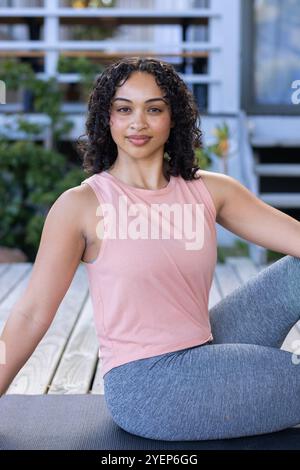 Donna sorridente che pratica yoga sul ponte, godendo di un ambiente tranquillo all'aperto. Meditazione, benessere, fitness, relax, tranquillità, esercizio fisico Foto Stock