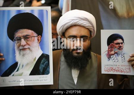 Teheran, Iran. 31 ottobre 2024. Un ecclesiastico iraniano regge un manifesto del leader supremo iraniano Ayatollah Ali Khamenei (L) e ha ucciso il chierico libanese Hashem Safieddine (R) durante una cerimonia in Piazza Palestina a Teheran, per commemorare il defunto Hashem Safieddine, un importante chierico che doveva succedere al leader assassinato di Hezbollah Hassan Nasrallah, ucciso da un attacco aereo israeliano a Beirut. (Credit Image: © Rouzbeh Fouladi/ZUMA Press Wire) SOLO PER USO EDITORIALE! Non per USO commerciale! Foto Stock