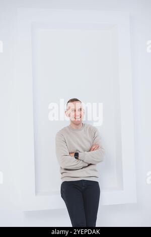 Un uomo su sfondo bianco è vestito con pantaloni raglan e neri. Abbigliamento casual da uomo. Foto Stock