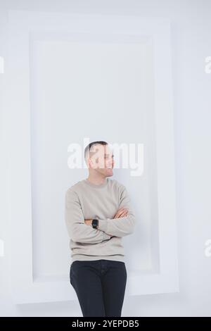 Un uomo su sfondo bianco è vestito con pantaloni raglan e neri. Abbigliamento casual da uomo. Foto Stock