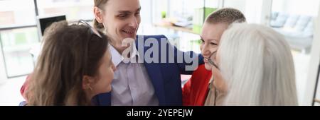 I dipendenti aziendali si abbracciano per supportare e ispirare in ufficio Foto Stock