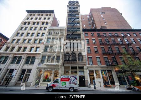 Questa fotografia cattura una fila di edifici classici di New York City con intricati dettagli architettonici e fughe di fuoco esterne. Foto Stock