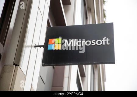 Questa immagine mostra un cartello Microsoft con l'iconico logo quadricromatico dell'azienda su un elegante sfondo nero, attaccato all'esterno Foto Stock