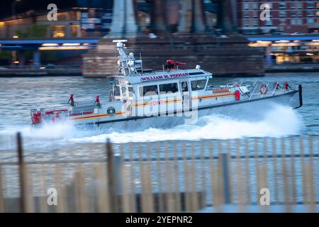 Fotografia di una barca dei vigili del fuoco della FDNY di nome William M. Feehan che sfreccia nell'acqua, creando uno spruzzo di onde mentre si muove. Foto Stock