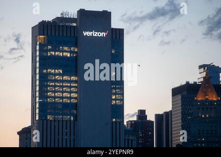 Le finestre illuminate e il logo "Verizon" risaltano sulla facciata elegante e moderna dell'edificio. Foto Stock