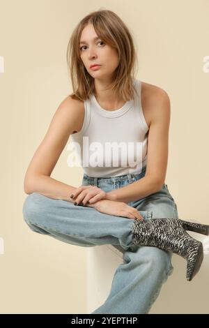 Serio di foto in studio di donna in classico abito base - jeans blu e canotta bianca Foto Stock