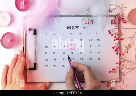 Calendario 9 maggio. Candele fiori piuma. Buon giorno delle madri. Pianificazione delle vacanze. Disposizione piatta. Vista dall'alto. Celebrazione Foto Stock