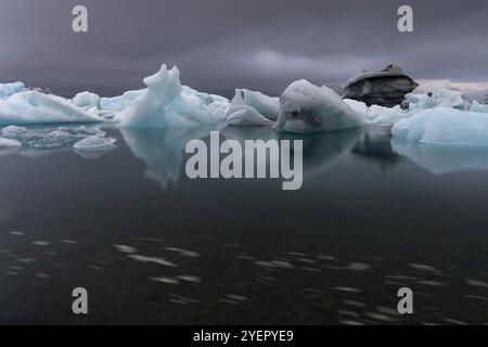 Iceberg sotto nuvole scure, drammatico e minaccioso, esposizione lunga, laguna ghiacciata Joekulsarlon o Joekulsarlon, Islanda del Sud, Islanda, Europa Foto Stock