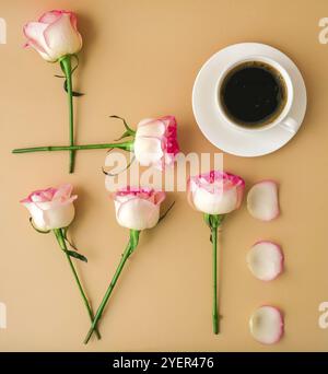 Parola AMORE fatto di fiori rosa rosa tenue rose e caffè tazza su sfondo beige. Concetto di amore. Giacitura piatta. Composizione minima. Romantico rosa pastello Foto Stock