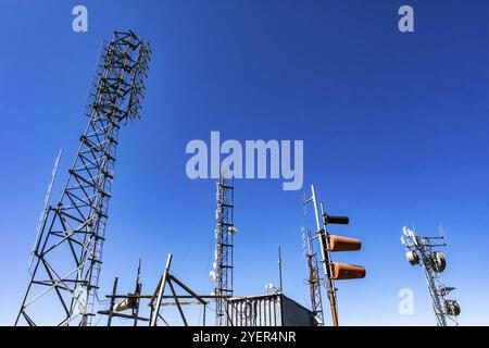 Un basso angolo di visione della radio GPS reticolo di comunicazione di torri di acciaio e la rete cellulare stazione base per la trasmissione e la ricezione di segnali di diffusione Foto Stock