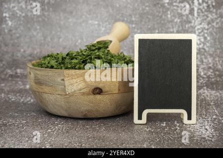 Adattogeni di prezzemolo verde fresco essiccato con mockup modello spazio copia lavagna vuota. Erboristeria mangiare sano. Prebiota superfood Foto Stock