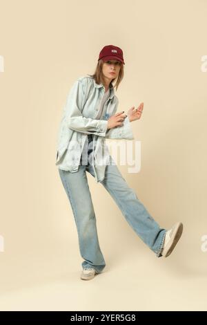 Serie di foto in studio di donna in un outfit casual moderno, jeans blu, canotta bianca e camicia in denim. Foto Stock