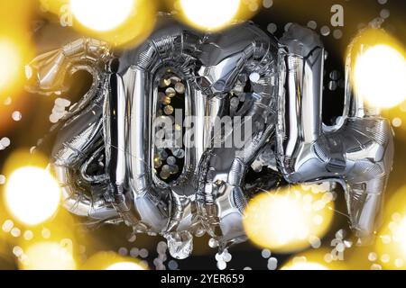 Holiday bokeh garland felice anno nuovo 2024 palloncini metallizzati con coriandoli su sfondo nero scuro. Biglietto d'auguri con palloncini in lamina d'argento, numeri Christm Foto Stock