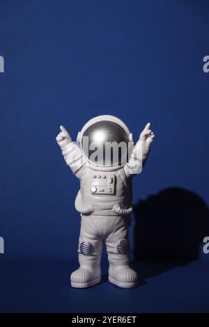 Astronauta giocattolo di plastica su sfondo blu colorato spazio copia. Concetto di viaggio fuori terra, voli commerciali per astronauti privati. Missioni spaziali e. Foto Stock