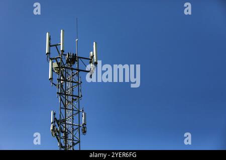 Dettagli di antenna multipla sulla cima di un acciaio torre tralicciata contro un cielo blu con copia spazio sulla destra. Dati mobili e la tecnologia di scambio di trasmissione Foto Stock