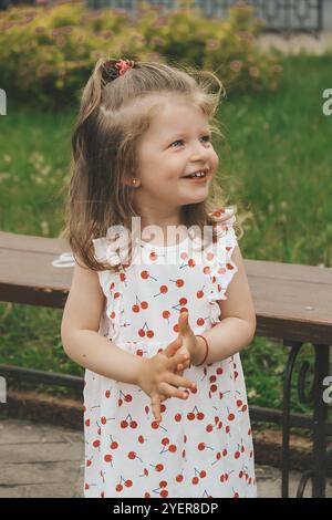 Ritratto di bambino ragazzino. Felice ragazzo sorridente. Tempo di riproduzione. Felice infanzia fuori. Bella ragazza piccola con gli occhi blu. Parco natura Foto Stock