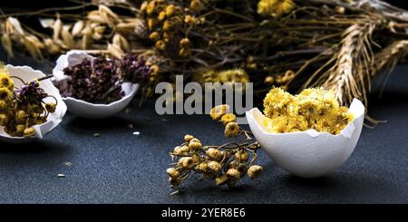 Fai da te di Pasqua. Fai da te. Decorazioni pasquali alla moda. Uova biologiche cracked con erba secca e fiori secchi su piatto. Piuma d'uccello. Spazio di copia. Greetin Foto Stock