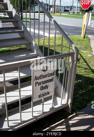 Il personale autorizzato firma solo sulle scale metalliche del centro storico di Kissimmee in Florida, USA, ottobre 2024, con la strada e il segnale di stop dietro - non c'è nessuno Foto Stock