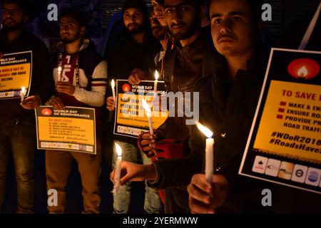 Una grande folla di persone partecipa ad una veglia per ricordare le vittime degli incidenti stradali a Srinagar, in India, nel Kashmir, in occasione della giornata mondiale della memoria per le vittime del traffico stradale il 18 novembre 2018. I partecipanti tengono striscioni che chiedono al governo di adottare e applicare buone leggi sulla sicurezza stradale, per garantire la sicurezza di strade e veicoli e per fornire prontamente assistenza di emergenza alle vittime del traffico stradale. Secondo il ministero indiano del trasporto stradale e delle autostrade, lo Stato indiano di Jammu e Kashmir è al secondo posto in India per gli incidenti stradali, con una media di oltre 900 dea Foto Stock