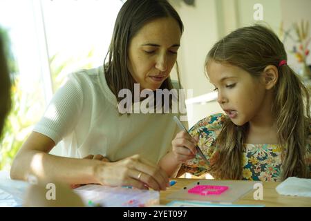 L'insegnante in officina ha messo in tecnica due ragazze come assemblare un mosaico termico Foto Stock