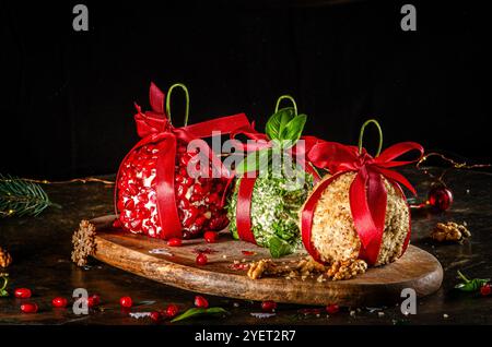 Palle di formaggio cottage con noci, erbe e melograno, sparate da vicino su una tavola di legno su uno sfondo scuro Foto Stock