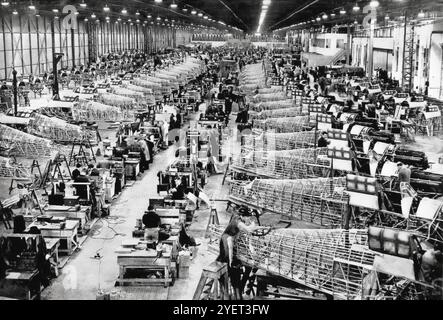 Linea di produzione di fabbrica dell'Hawker Hurricanes, un caccia monoposto britannico degli anni 1930-40, progettato e costruito principalmente dalla Hawker Aircraft per il servizio con la Royal Air Force (RAF). Fu messo in ombra dalla coscienza pubblica dal Supermarine Spitfire durante la battaglia d'Inghilterra nel 1940, ma l'uragano inflisse il 60% delle perdite subite dalla Luftwaffe nella campagna, e combatté in tutti i principali teatri della seconda guerra mondiale. Foto Stock