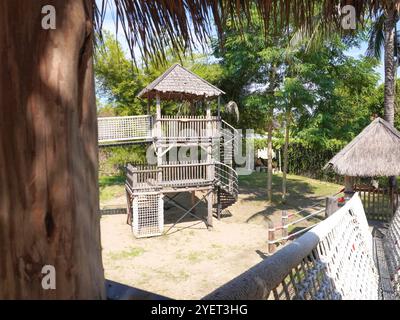 Parco giochi estivo con altalene, scivoli e attrezzature per arrampicata. Moderno parco giochi in legno per bambini. Foto Stock