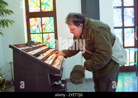 Credente religioso cattolico che brucia candele. Un credente religioso cattolico che brucia candele all'interno della cattedrale di San Giuseppe di Sofian. Sofia, Bulgaria. MRYES Sofia Ulitsa Knyaz Boris i 125 Sofia Bulgaria Copyright: XGuidoxKoppesxPhotox Foto Stock